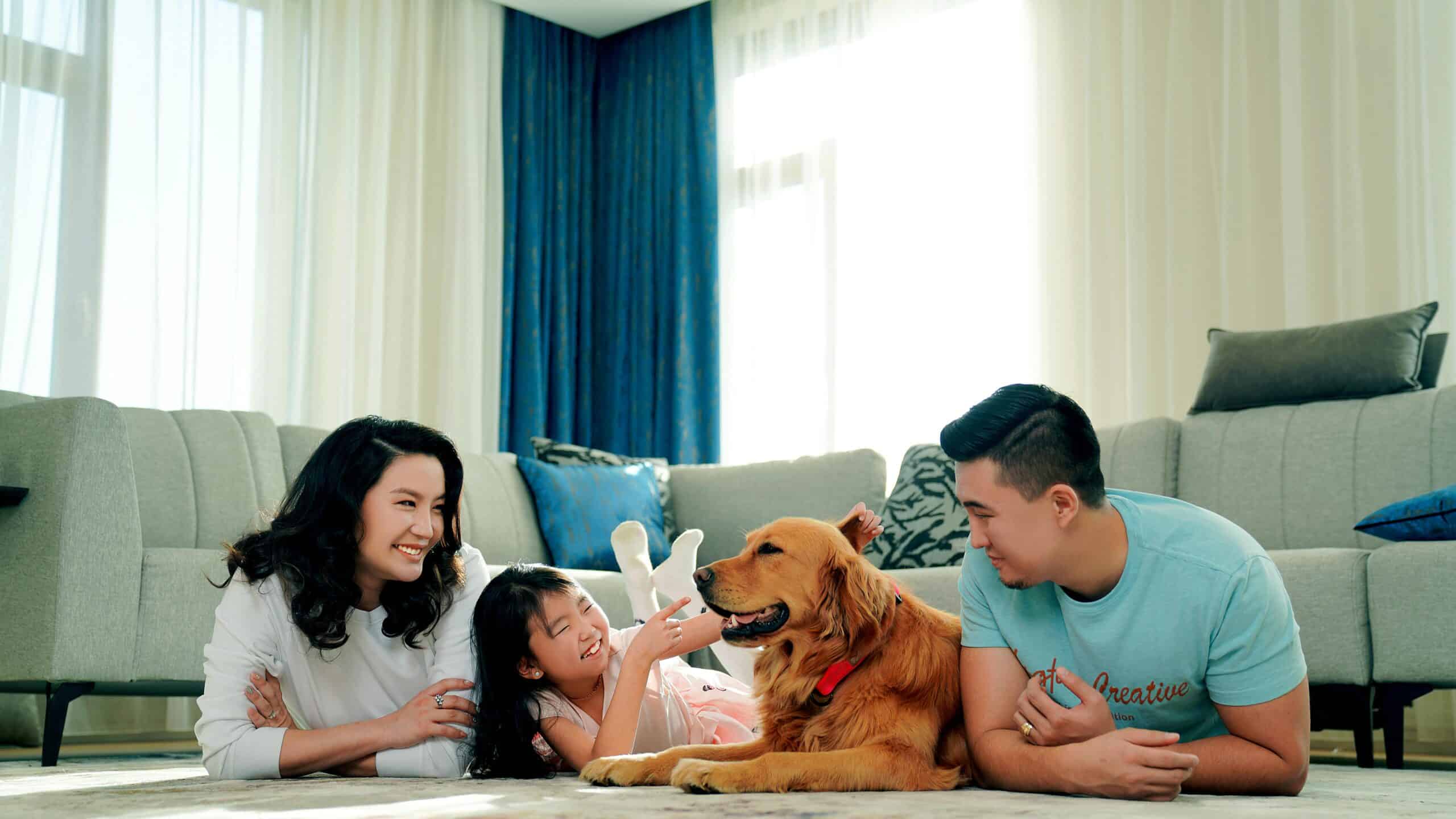 Happy family relaxing in a clean home with their dog
